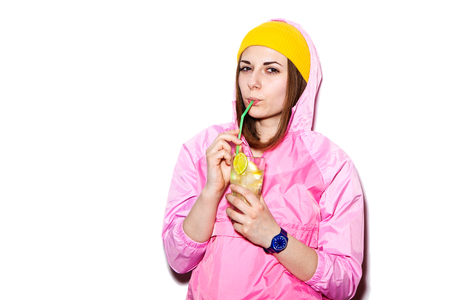 Beautiful girl drinking alcoholic cocktail. Sexy girl a pink jacket and refreshing cocktail drinksの写真素材