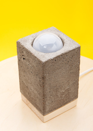 Fashion designer lamp made of concrete on a yellow backgroundの写真素材