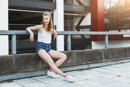 Young blonde girl spends time in the modern city. Female model posingの写真素材