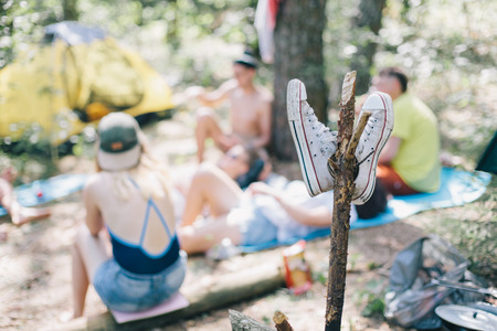 Group of young hipster people relaxing with tents in the woods. Rest in the woods with friendsの写真素材