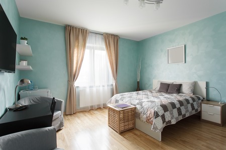 Spacious bedroom in blue color with a double bed. Interior design