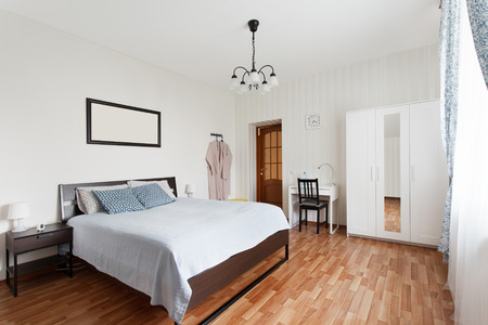 Bright bedroom with double bed and small workplace. Interior designの写真素材