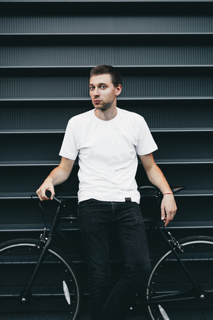 Young hipster man with a fixed gear bike near the trendy colored wallの写真素材