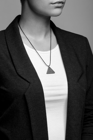 Portrait of a girl closeup with a concrete pendant around his neckの写真素材