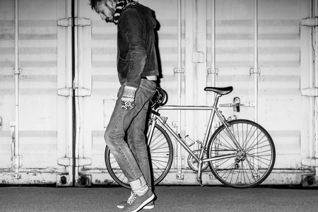 Male hipster on fixed-gear bicycle at night. Black and white portraitの写真素材