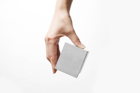A womans hand holds a box made of concreteの写真素材