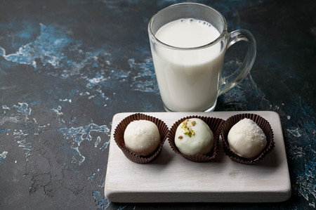 Handmade chocolates with cheese stuffing on a dark background. white milk chocolate. clouse upの写真素材