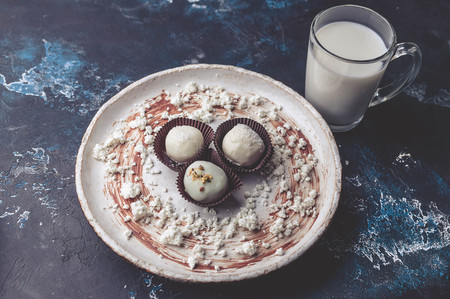 Handmade chocolates with cheese stuffing on a dark background. white milk chocolate. clouse upの写真素材