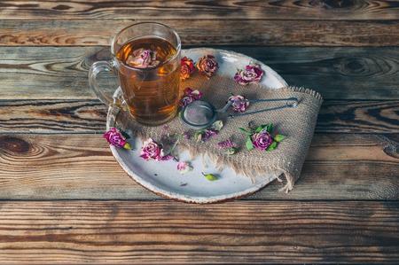 Rose buds tea, tea cup, strainer and glass jar with rosebuds. Selective focus.の写真素材