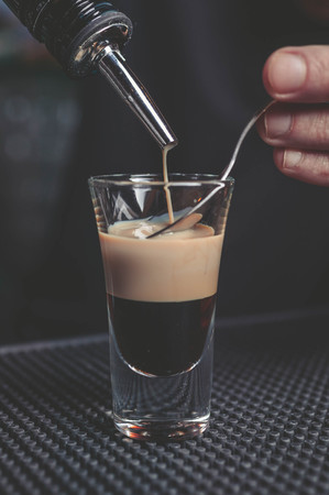 The bartender prepares a B-52 cocktail at the bar