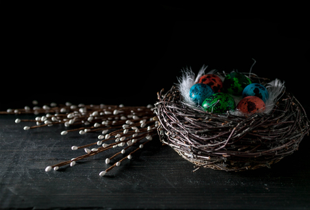Multi-colored eggs on a dark background. Easter still life in a low key. Dark rustic background with copy spaceの写真素材