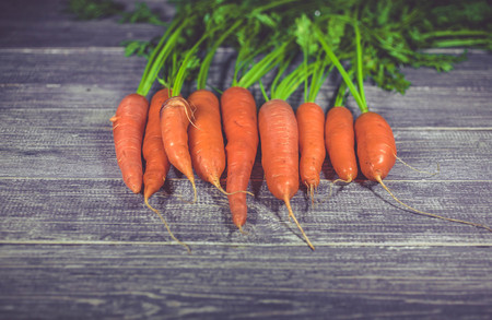 Fresh carrots on a wooden table. Healthy food background.の写真素材