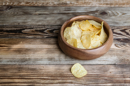 Chips in a bowl. A snack for beer on a wooden table.の写真素材