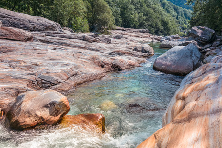 The mountain river with clear water flowing between stones from the glacierの写真素材