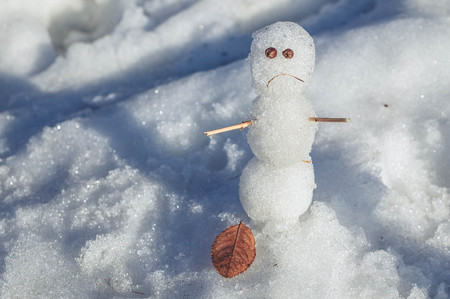 Sad snowmen. Spring came and the snow meltsの写真素材