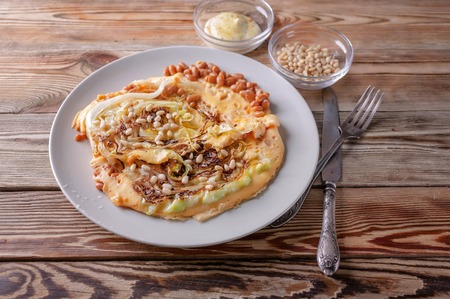 Vegetarian Omelette with fried cabbage, beans and spices on a wooden table. Healthy breakfast...