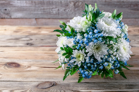 Wedding bouquet of white and blue chrysanthemums on a wooden backgroundの写真素材