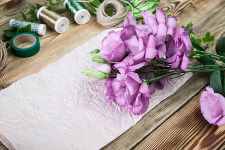 Workplace florist. Flowers and accessories for making bouquets on a wooden backgroundの写真素材
