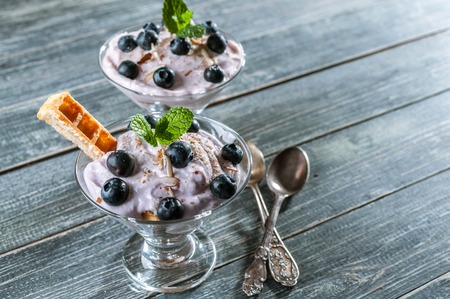 Curd dessert with blueberries and slices of Viennese waffles in a glass cup.の写真素材