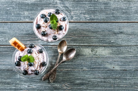 cottage cheese dessert with blueberries and slices of Viennese waffles in a glass cup. Top view. Copy spaceの写真素材
