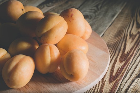 Apricots on a wooden background. Summer healthy fruits. Low key lighting