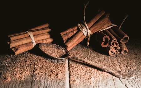 Cinnamon sticks on a wooden background. Low key lighting