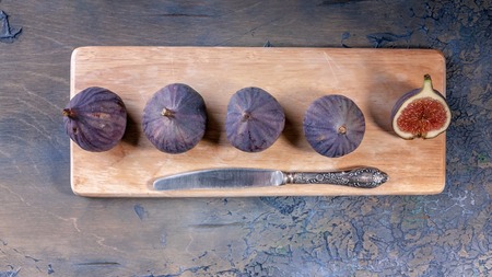 Figs and a knife on a cutting board. Close-up. Top view