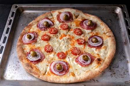 Italian pizza with cheese and olives on a baking sheet. Close-Upの写真素材