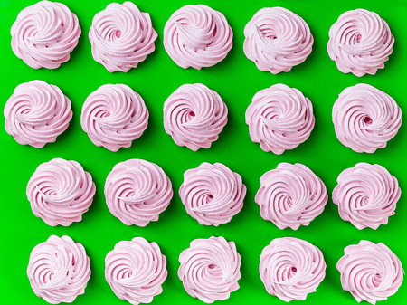 Pink fruit marshmallows on a green background. Top viewの写真素材