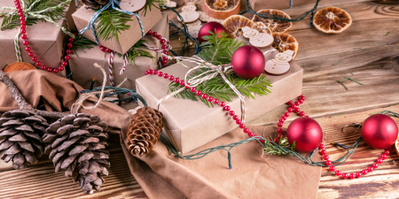 Christmas background. Christmas gifts, fir branches, cones and Christmas decorations on a wooden background. Bannerの写真素材