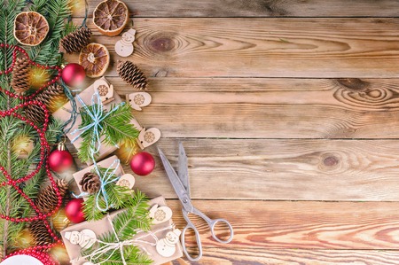 Christmas background. Christmas gifts, fir branches, cones and Christmas decorations on a wooden background. Copy spaceの写真素材