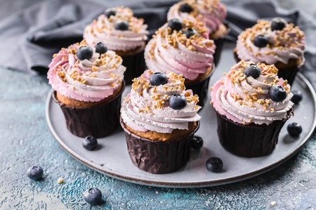 Delicious cupcakes with blueberry cream, fresh blueberries and nut sprinkel.の写真素材