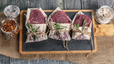 Raw meat steaks and vegetables. Fresh meat on a cutting board. Top viewの写真素材