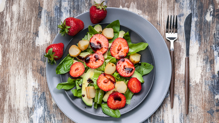 Delicious salad with greens, strawberries and smoked cheese. Tasty and healthy. Top view. Food bannerの写真素材