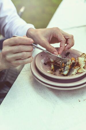 Woman eating sea bass grill. Summer party in the backyard. Vertical shotの写真素材