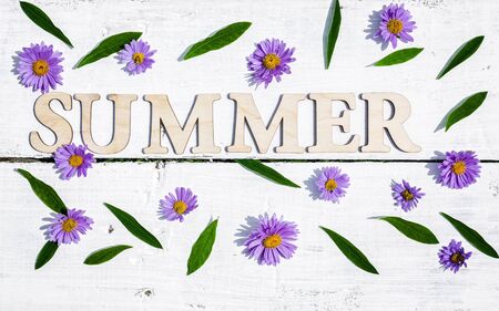 The word summer on a white wooden rustic background. Summer flat lay compositionの写真素材