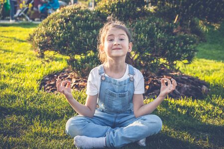 Happy young girl practice yoga in lotus pose in a japanese garden. Calm and happy teenagerの写真素材