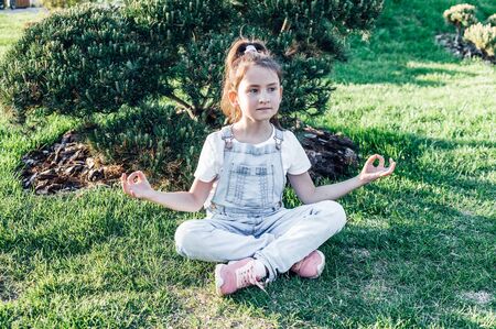 Sweet girl meditates in the Japanese garden. Calm and happy childの写真素材