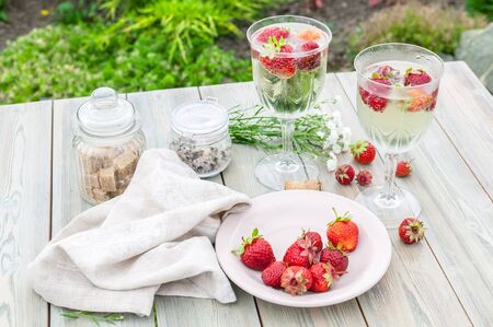 Champagne wine and strawberries. Summer food composition on a wooden table.の写真素材