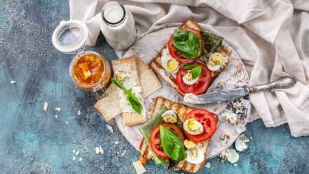 Toasts with cheese, fresh tomatoes, basil leaves and quail eggs. Tasty and healthy breakfast...