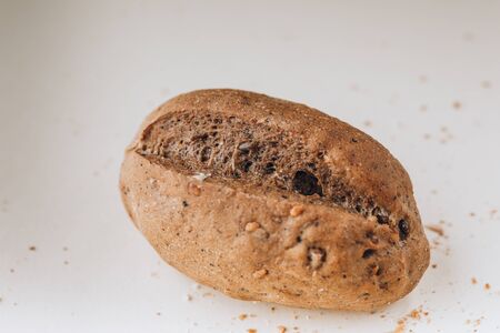 Rye bun with sunflower seeds and nuts on a light background