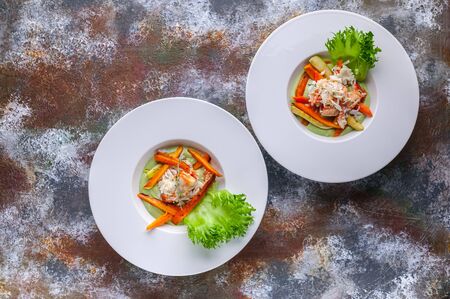 Salad with snow crab meat, avocado and vegetables. Two servings on a rusty background. Horizontal shotの写真素材