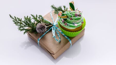 Christmas traditional muffin and gift box in craft paper on a white background. Top view