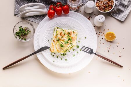 Top view vegetarian lasagna with spinach and microgreens on a white plate. Tasty and healthy mediterranean food.の写真素材