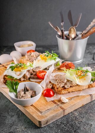 Vertical shot sandwiches with fish pate, herbs and cheese on a wooden cutting board. Close-upの写真素材