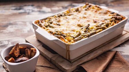 Food banner baked vegetable lasagna with green beans and cheese in a ceramic bowl. Healthy...