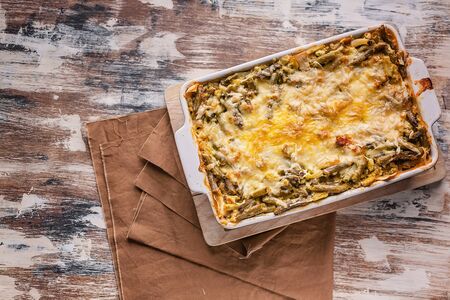 Baked vegetable lasagna with green beans and cheese in a ceramic bowl. Healthy vegetarian food. Top...