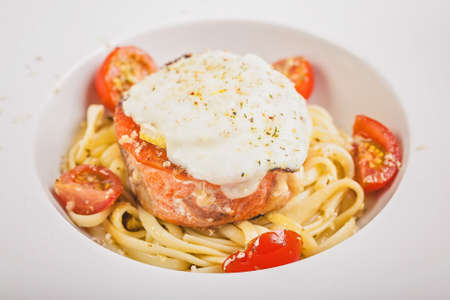 Close-up pasta with pink salmon, cherry tomatoes and ricotta sauce with lemon. Delicious seafood...