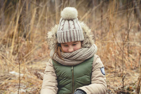 Portrait of a Girl in a knitted cap on a background autumn forest. Hiking in the forest concept. Late fallの写真素材