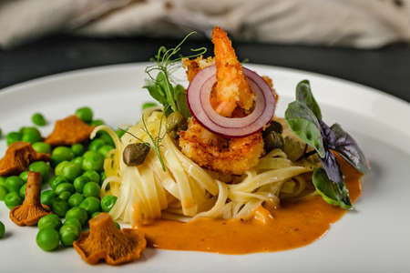 Close-up pasta and fried shrimps with green peas and original chanterelle sauce. Healthy and tasty food. Chef Original Recipe.の写真素材